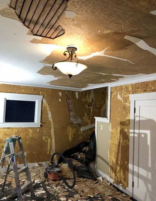 Removing damaged lath and plaster from living room walls, ceiling, and stairway.